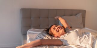 Ženska se sprošča na postelji v mirnem jutru