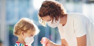 mati razkužuje roke otroku