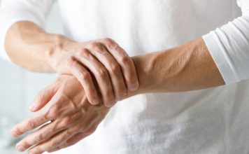 Odpravimo bolečino v sklepih Oseba si zaradi bolečine drži zapestje in sklepe rok