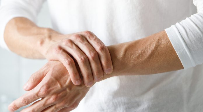 Odpravimo bolečino v sklepih Oseba si zaradi bolečine drži zapestje in sklepe rok