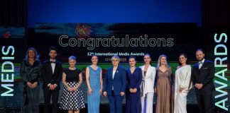 Skupinska fotografija zmagovalcev 12. International Medis Awards s predsednico Republike Slovenije na odru.
