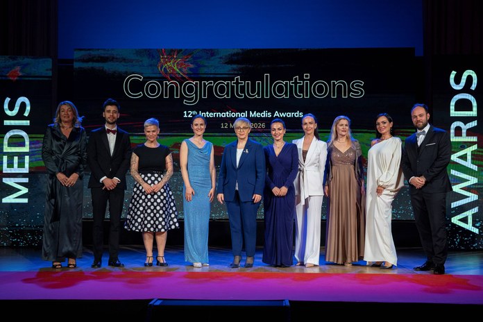 Skupinska fotografija zmagovalcev 12. International Medis Awards s predsednico Republike Slovenije na odru.
