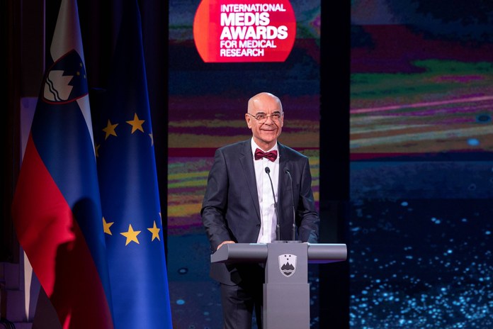 Tone Strnad stoji za govorniškim pultom na slovesnosti International Medis Awards.